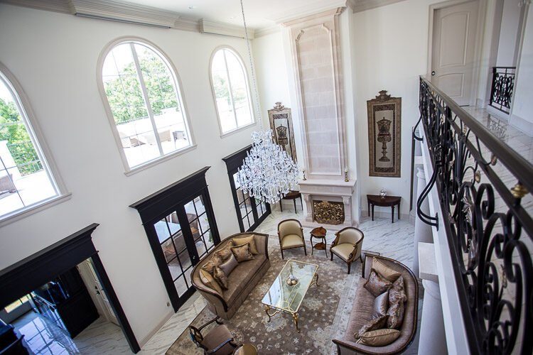 A signature Antiquity Design room — bright living space with arched windows and antiques